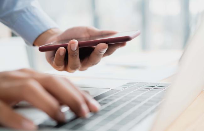 businessman-using-smartphone-and-computer-keyboard-2021-09-03-04-16-18-utc.jpg