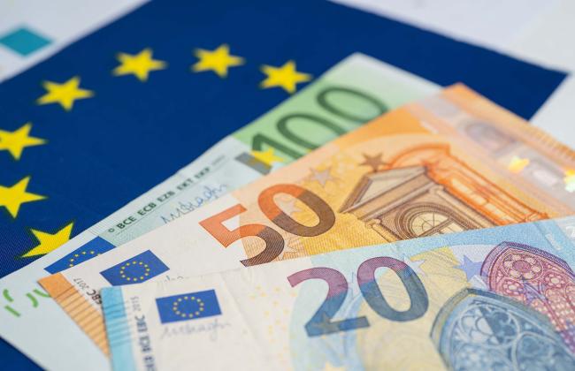 euro-banknote-on-eu-flag-2021-12-09-19-28-38-utc.jpg